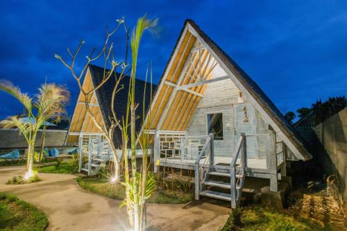 a tiny house with a porch at night at D'Yuki Huts Lembongan in Nusa Lembongan