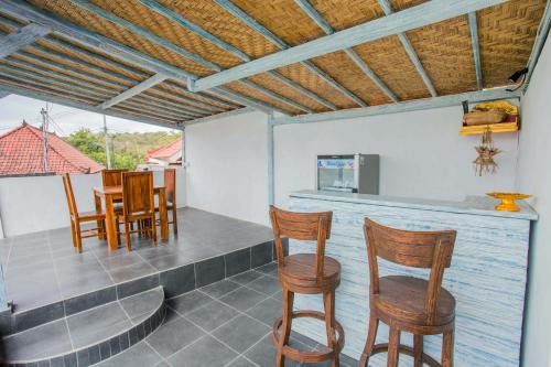 a bar with chairs and a table in a room at D'Yuki Huts Lembongan in Nusa Lembongan