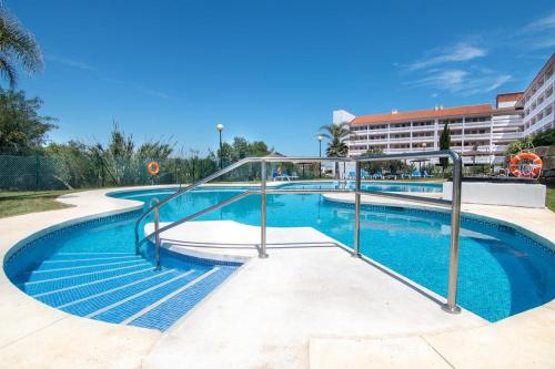 a swimming pool with a metal handrail next to a building at Manilva Playa in Manilva