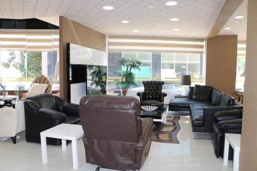 a living room with couches and chairs and tables at Business Grand Hotel in Ankara