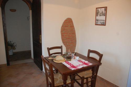 a table and chairs with a surfboard on the wall at Agriturismo Lupo Vecchio in Grosseto