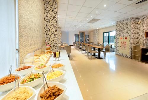 una línea de buffet con tazones de comida en una cafetería en OHYA Chain Boutique Motel-Yongkang en Yongkang