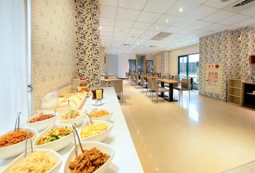 a buffet line with bowls of food in a cafeteria at OHYA Chain Boutique Motel-Yongkang in Yongkang