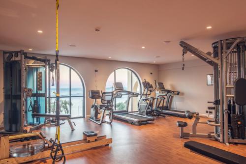 a gym with a lot of treadmills and ellipticals at Nido, Mar-Bella Collection in Agios Ioannis Peristeron