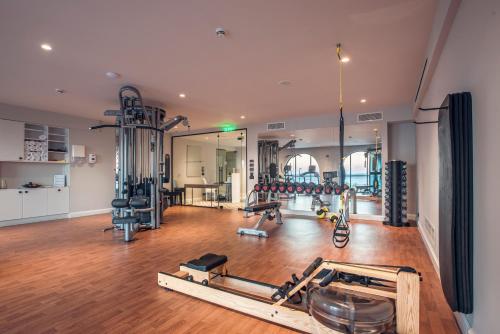 a gym with several treadmills and weights in a room at Nido, Mar-Bella Collection in Agios Ioannis Peristeron