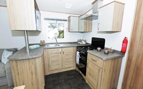 a small kitchen with a sink and a stove at Mersea Island by Away Resorts in Colchester