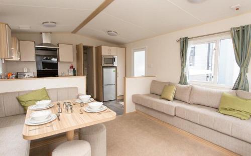 a living room with a couch and a table at Mersea Island by Away Resorts in Colchester
