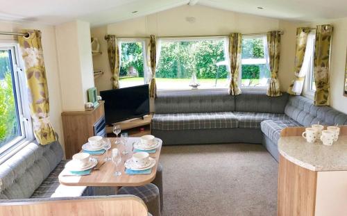 a living room with a couch and a table at Mersea Island by Away Resorts in Colchester