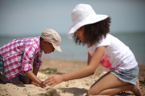 two girls playing in the sand on the beach at Mersea Island by Away Resorts in Colchester