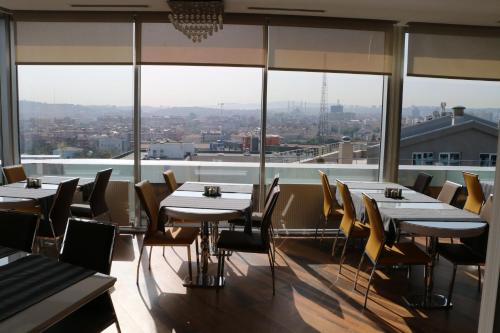 a restaurant with tables and chairs and a view of the city at Business Grand Hotel in Ankara