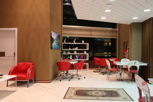 a dining room with red chairs and tables at Business Grand Hotel in Ankara
