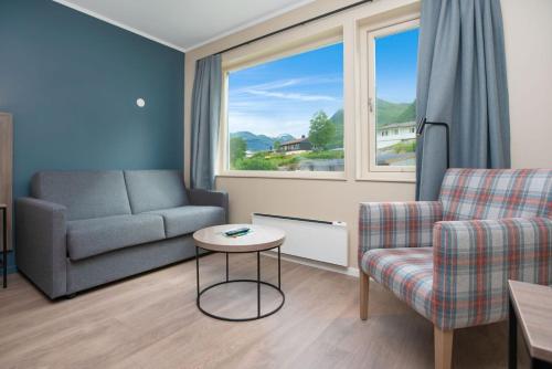 a living room with a couch and a chair and a table at Grand Hotel Skei - Unike Hoteller in Skei 