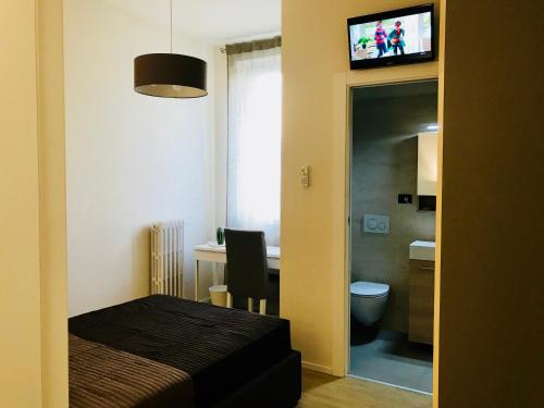 a bedroom with a bed and a desk and a television at Nontiscordardime in Orsogna