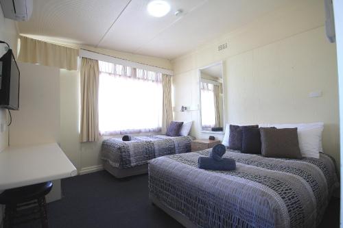 a hotel room with two beds and a window at Hi Way Motor Inn in Yass