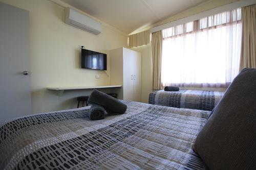 a bedroom with a large bed with a large window at Hi Way Motor Inn in Yass