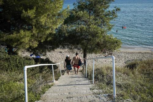 a man and woman walking down the stairs to the beach at Nektarios Garenias Kipoupoli in Nea Kalikratia