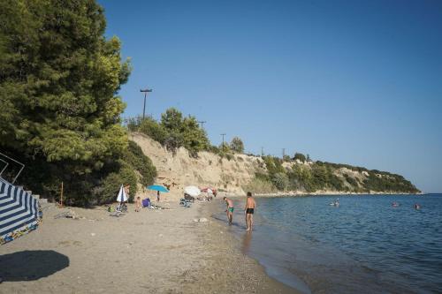 a group of people on a beach near the water at Nektarios Garenias Kipoupoli in Nea Kalikratia