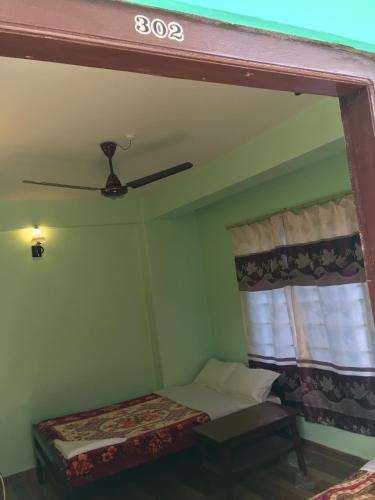 a small room with a bed and a window at Harry Guest House & Restaurant in Pokhara