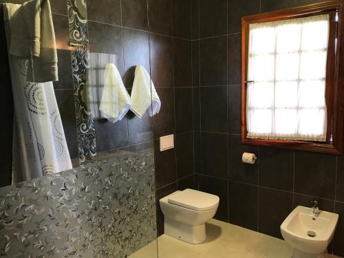 a bathroom with a toilet and a window at Il Sogno di Gio de la Laguna in La Laguna