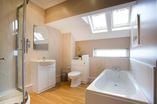 a bathroom with a sink and a toilet and skylights at Breckland Lodge in Attleborough