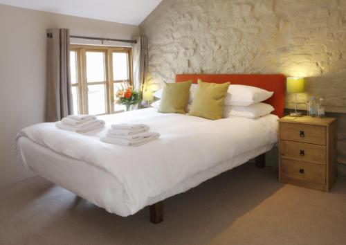 Un dormitorio con una gran cama blanca y una ventana en The Lamb Inn, en Crediton