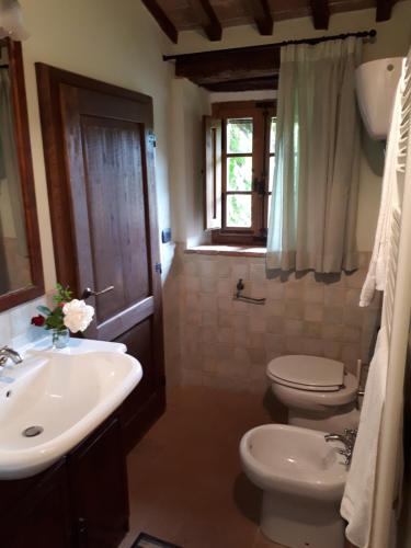 a bathroom with a sink and a toilet and a window at Castellare in Chiusdino