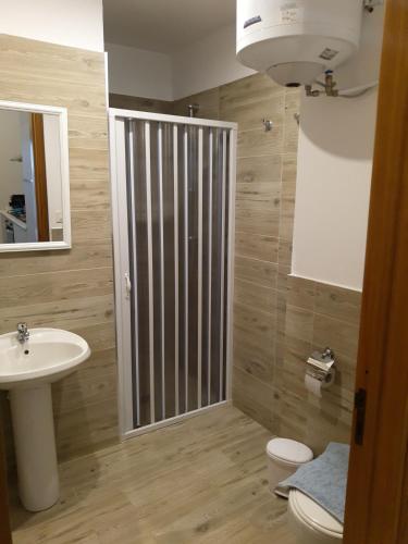 a bathroom with a sink and a toilet and a mirror at Thomas'home in Comiso