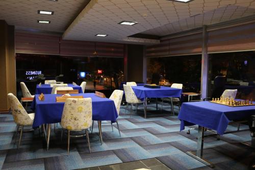 a dining room with blue tables and white chairs at Business Grand Hotel in Ankara