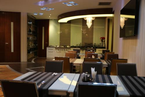 a dining room with tables and chairs in a restaurant at Business Grand Hotel in Ankara