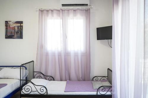 a bedroom with two beds and a window at Nektarios Garenias Kipoupoli in Nea Kalikratia