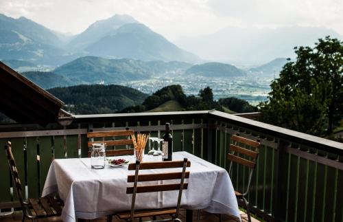 a table with a white table cloth on a balcony with mountains at Ferienwohnung Morgengabe in Fraxern