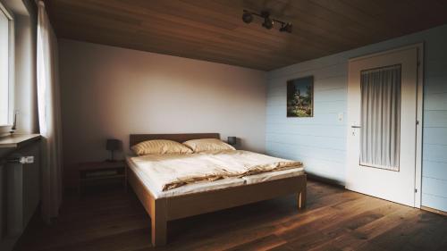 una camera con letto e pavimento in legno di Ferienwohnung Morgengabe a Fraxern