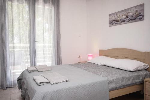 a bedroom with a bed with two towels on it at Nektarios Garenias Kipoupoli in Nea Kalikratia
