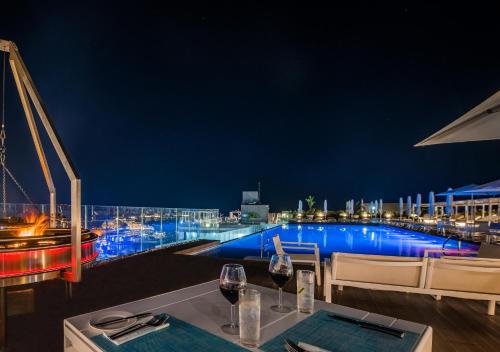 a restaurant with a view of a pool at night at InterContinental Malta by IHG in St Julian's