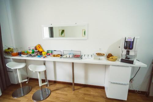 a white counter with stools in a kitchen at Bluemoon Sardinia in Cagliari