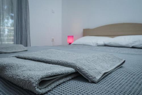 a bed with two towels on top of it at Nektarios Garenias Kipoupoli in Nea Kalikratia