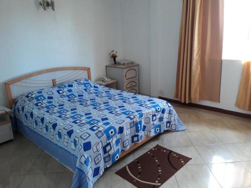 a bedroom with a bed with a blue and white comforter at Trochetia villa in Pereybere
