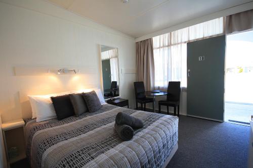a hotel room with a bed and a table with chairs at Hi Way Motor Inn in Yass