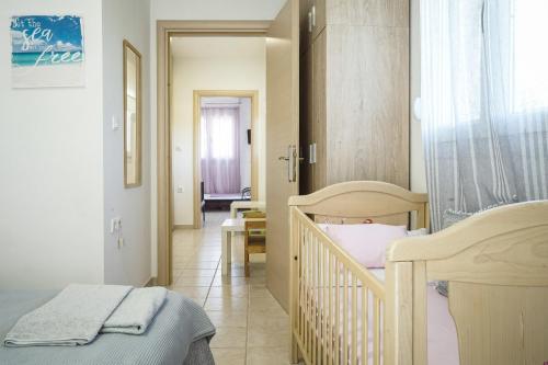 a bedroom with two beds and a hallway with a table at Nektarios Garenias Kipoupoli in Nea Kalikratia
