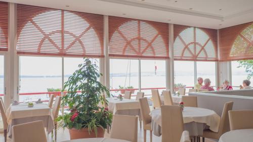 ein Restaurant mit Tischen und Stühlen und einem Weihnachtsbaum in der Unterkunft Hôtel Des Princes in Amphion les Bains