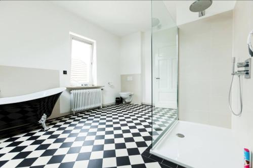a bathroom with a black and white checkered floor at Beautiful apartment in a historic villa in Hattingen