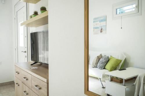 a mirror in a living room with a couch and a tv at Nektarios Garenias Kipoupoli in Nea Kalikratia