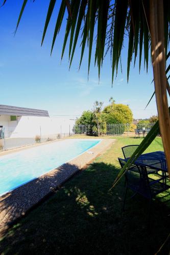 a view of a swimming pool with a chair at Hi Way Motor Inn in Yass