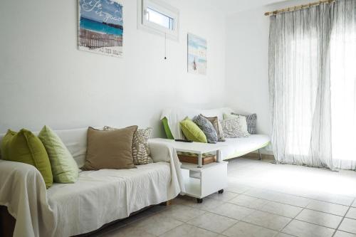 a living room with a couch with pillows on it at Nektarios Garenias Kipoupoli in Nea Kalikratia