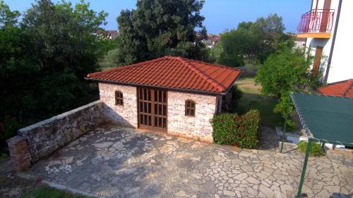 a small brick building with a red roof at Apartments Ana Wellness L in Rovinj