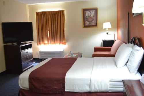 a hotel room with a large bed and a television at Red Carpet Inn Newark - Irvington NJ in Irvington