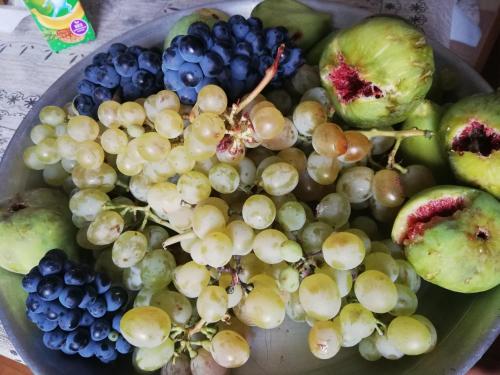 a bowl of grapes and other fruits on a table at Raul Lushnu Darbaz in Mestia