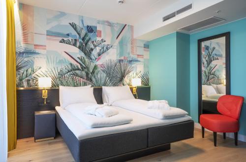 a bedroom with a bed and a red chair at Thon Hotel Storo in Oslo