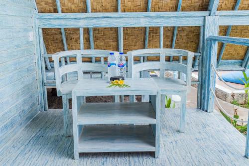 a blue table and chairs on a porch at D'Yuki Huts Lembongan in Nusa Lembongan