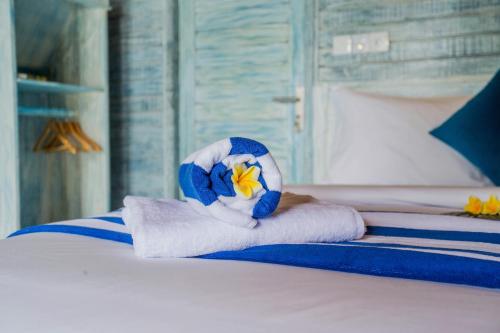 a bed with a towel with a stuffed animal on it at D'Yuki Huts Lembongan in Nusa Lembongan